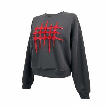 Zijkant van de antracietkleurige dames sweater van CLAU-D, voorzien van een opvallend rastermotief in rood gescheurd denim.