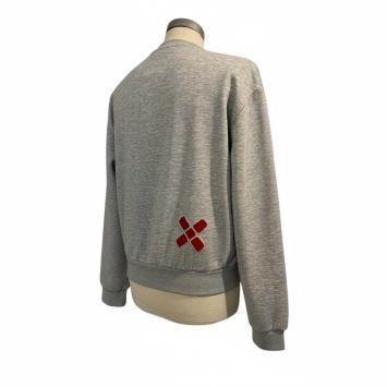 Achteraanzicht van de korte grijze sweater van CLAU-D, afgewerkt met een subtiel rood bontkruisje op het rugpand.